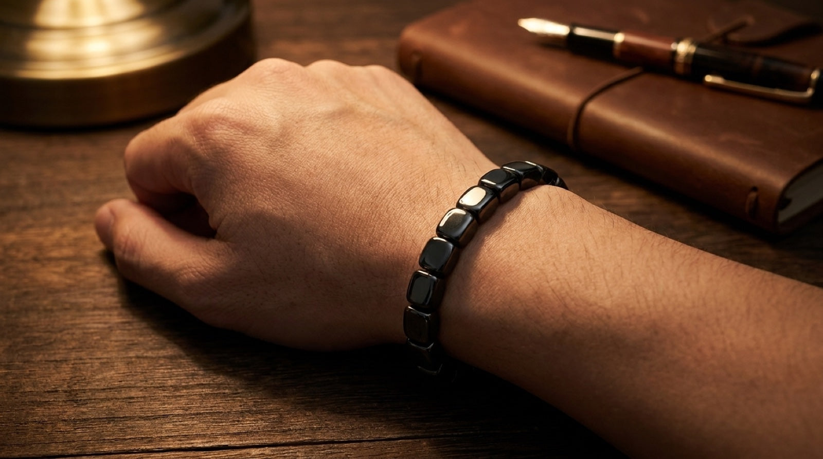 Close-up of VORTIS bracelet on wrist at desk — 30-day money-back guarantee